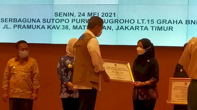 Kepala BNPB Doni Monardo secara simbolis menyerahan bantuan dana stimulan kepada Bupati Luwu Utara Indah Putri Indriani. Senin (24/05/2021)