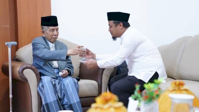 Plt Gubernur Sulsel Andi Sudirman Sulaiman, memberikan segelas Air Minum kepada AGH Sanusi Baco.