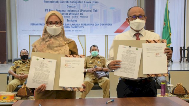 Bupati Luwu Utara Indah Putri Indriani menunjukkan naskah kerja sama dengan PT Bank Negara Indonesia (BNI) Persero Tbk Kantor Wilayah 07 (Sulsel-Sulbar-Sultra-Maluku) yang diteken bersama. (Senin 31/05/2021)