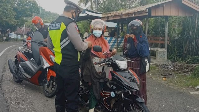 Anggota Satlantas Polres Sinjai mengecek surat-surat salah satu pengendara motor.