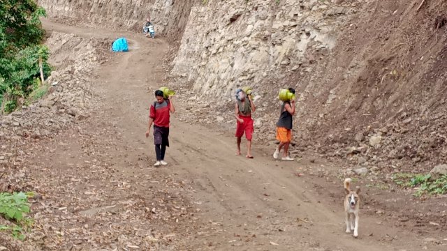 Jalan Licin Karena Hujan, Warga Tola Ramai-Ramai Bantu Pikul Logistik TMMD 111 Sejauh 3 KM