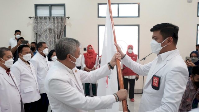 Ketua PMI Sulsel Adnan Purichta Ichsan, menyerahkan bendera PMI kepada Ketua PMI Pinrang terpilih yang juga Bupati Pinrang Irwan Hamid, Minggu (27/06/2021).