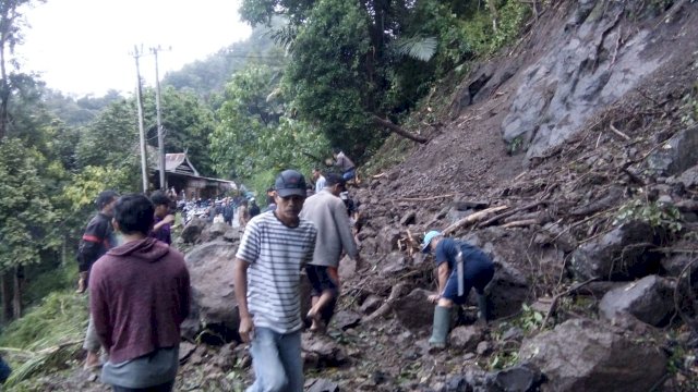 Masyarakat Desa Gantarang, Kecamtan Sinjai Tengah, Kabupaten Sinjai, bergotong royong memindahkan material longsor yang menutup jalan, Selasa (29/06/2021).