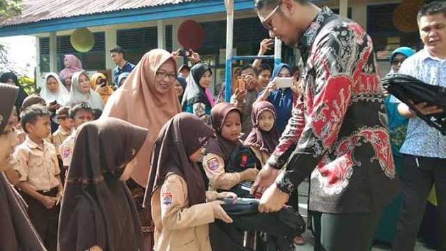 Bupati Sinjai, Andi Seto Gadhista Asapa saat menyerahkan seragam sekolah gratis kepada murid sekolah dasar (SD) belum lama ini.