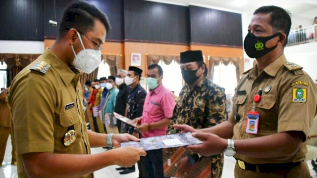 Bupati Sinjai, Andi Seto Gadhista Asapa saat menyerahkan SK Tentang Pemberhentian Kepala Desa dan Penunjukan Penjabat Kepala Desa di Kabupaten Sinjai di Ruang Pola Kantor Bupati Sinjai, Selasa (13/7/2021).