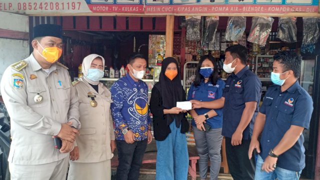 Jajaran pengurus NasDem Palopo saat menyerahkan bantuan modal usaha kepada Hasmiani, Jumat (6/8/2021).