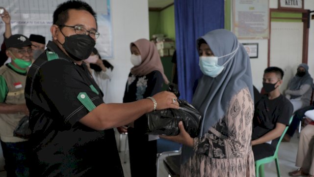 Ketua Majelis Daerah Korps Alumni Himpunan Mahasiswa Islam (Kahmi) Kabupaten Luwu Utara, Muhammad Fauzi menyerahkan paket sembako ke salah satu masyarakat Desa Waelawi. Rabu (15/09/2021)