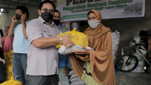 Anggota DPR RI Muhammad Fauzi menyerahkan paket sembako kepada salah satu masyarakat Desa Radda. Kamis (16/09/2021)