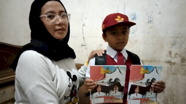 Orangtua Murid SDN 3 Sinjai Surni Alam, memperlihatkan anaknya yang mendapatkan bantuan pakaian seragam gratis dari pemerintah Kabupaten.