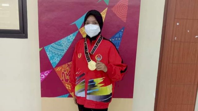 Atlet Muaythai Sulsel Sri Eviyanti, menunjukkan medali emas yang ia raih di PON XX Papua.