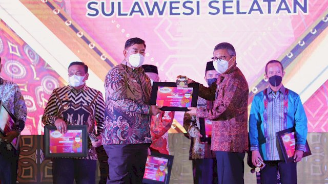 Sekda Prov Sulsel Abdul Hayat Gani, memberikan penghargaan TPAKD Terbaik kepada Wali Kota Parepare Taufan Pawe, pada Toraja Highland Festival dan Bulan Inklusi Keuangan 2021, di Toraja Utara, Senin (04/10/2021).