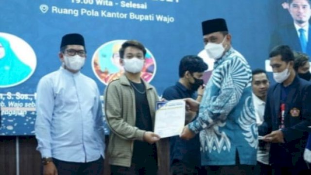 Bupati Wajo Amran Mahmud, menyerahkan penghargaan kepada Ketua Karang Taruna Kabupaten Wajo.