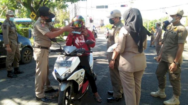 Satgas covid-19 Sinjai saat memakaikan masker kepada salah satu pengendara motor, Selasa (19/10/2021).