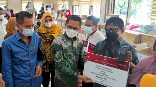Anggota DPR RI Komisi VIII, MF Nurhuda Y saat menyerahkan bantuan dari Kemensos ke masyarakat penerima