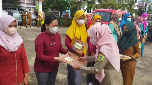 Kepala Dinas Kesehatan Kabupaten Sinjai dr. Emmy Kartahara Malik, menyerahkan penghargaan kepada Tenaga Kesehatan dan Puskrsmas terbaik, berlangsung di Halaman Kantor Dinas Kesehatan Kabupaten Sinjai, Senin (15/11/2021).