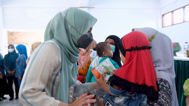 Ketua TP PKK Gowa Priska Paramita Adnan, berdialog dengan salah satu ibu yang menggendong anaknya saat penyerahan bantuan makanan bergizi, Jumat (19/11/2021).