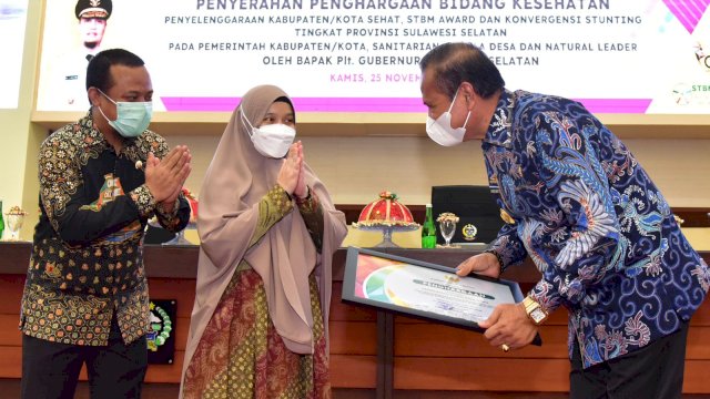 Plt Ketua TP PKK Sulsel Naoemi Octarina, menyerahkan Piagam Penghargaan kepada Bupato Luwu Basmin Mattayang, Kamis (25/11/2021).