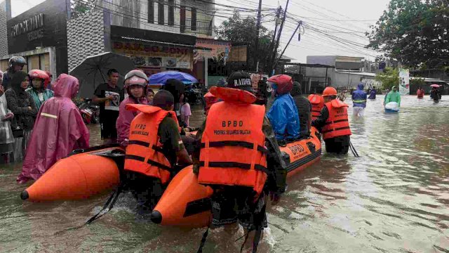 Petugas BPBD Sulsel melakukan evakuasi warga korban banjir di Makassar, Selasa (07/12/2021).
