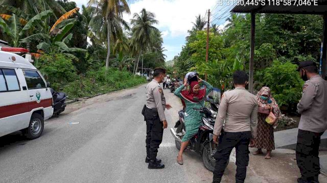Anggota Polisi Majene berbincang dengan salah satu warga yang mengunjungi Gerai Vaksin Polres Majene, Rabu (08/12/2021).