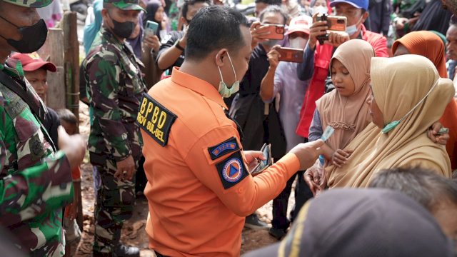 Plt Gubernur Sulsel Andi Sudirman Sulaiman, mengeluarkan dompetnya memberi uang jajan kepada salah satu anak saat berdialog dengan warga Pulau Bonerate di Kabupaten Kepulauan Selayar, Minggu (19/12/2021).