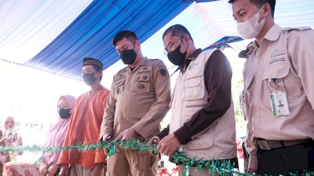 Bupati Gowa Adnan Purichta Ichsan dan Dewan Pembina Yayasan AMCF Ali Bakri, menggunting pita peresmian Rumah Duafa di Desa Timbuseng, Kecamatan Pattallassang, Selasa (21/12/2021).