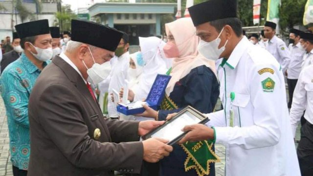 Gubermur Kaltim Isran Noor menyerahkan penghargaan Satya Lencana Karya Satya kepada tiga pegawai Kanwil Kemenag Kaltim, Senin (03/01/2022).