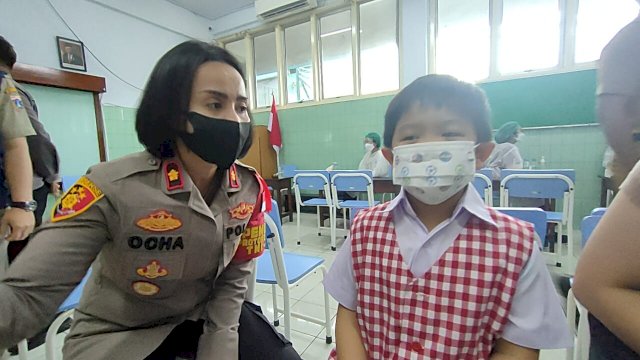 Kapolsek Tanjung Duren Kompol Rosana Albertina Labobar, berbincang dengan salah satu anak yang mengikuti vaksinasi di SD Bunda Hati Kudus, Jakarta Barat, Senin (10/01/2022).
