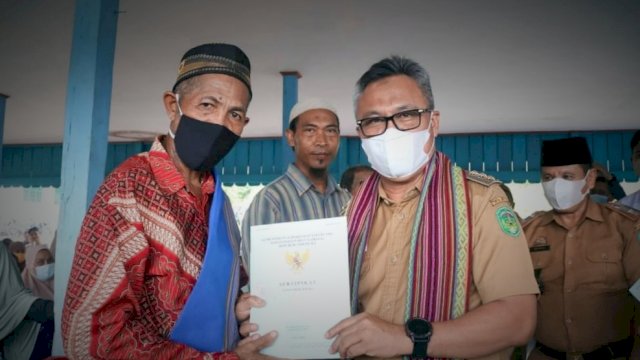  Bupati Luwu Timur, Budiman saat menyerahkan sertifikat tanah kepada warga transmigrasi Desa Harapan