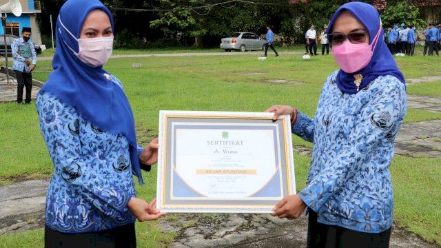 Bupati Luwu Utara Indah Putri Indriani, menyerahkan Piagam kepada salah satu perwakilan SKPD yang meraih Penghargaan Inovasi, Senin (17/01/2022).