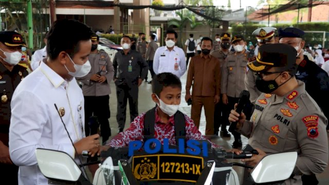 Kapolres Kendal AKBP Yuniar Ariefianto, berbincang dengan salah satu murid SD yang duduk di atas Moge setelah divaksin Dusis Dua.