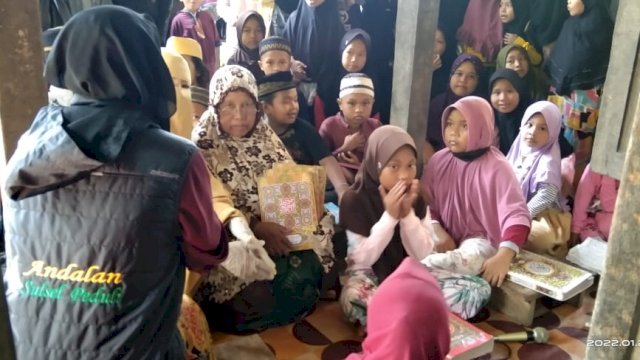 Tim Andalan Sulsel Peduli bersama Bidan Desa Mattombong, Hasriani menyalurkan bantuan Al Qur'an dari Pelaksana Tugas Gubernur Sulawesi Selatan Andi Sudirman Sulaiman, di dua titik di Desa Mattombong, Kecamatan Mattirosompe, Kabupaten Pinrang, Selasa (25/1/2022). 