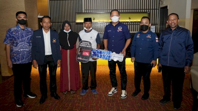 Ketua DPW NasDem Sulsel, Rusdi Masse saat menyerahkan hadiah mobil ke nelayan asal Takalar, Madda dalam acara Gebyar e-KTA di Hotel Claro, Makassar, Kamis (6/1/2022).