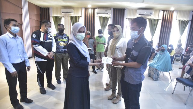 Bupati Luwu Utara, Indah Putri Indriani menyerahkan kunci huntap insitu kepada salah satu masyarakat penyintas banjir bandang. Jumat (04/02/2022)