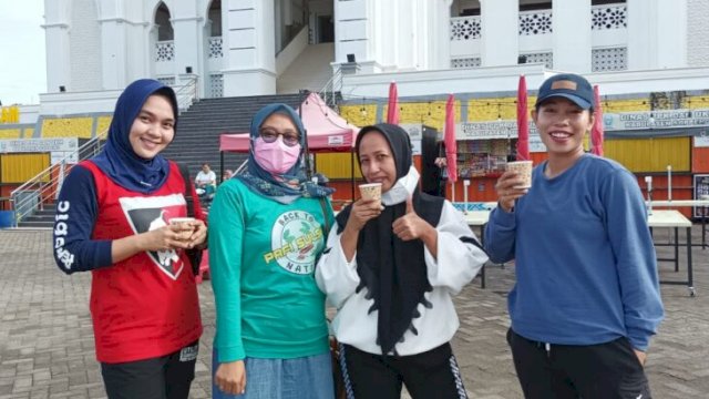 Pengurus PAFI Kabupaten Soppeng bersama warga memperlihatkan gelas Jamu Tradisional saat peringatan HUT PARI ke-76, di Car Free Day Depan Masjid Agung Watansoppeng, Minggu (13/02/2022).