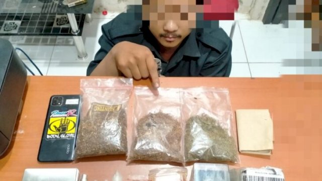 Pelaku AY (25), beraama barang bukti narkotika jenis tembakau gorila dan obat-obatan keras saat ditangkap Satresnarkoba Polresta Serang Kota Polda Banten pada Selasa (15/02/2022). (Foto. Humas Polres Kota Serang)