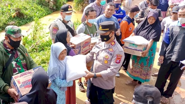 Kapolsek Cibeber Polres Lebak, AKP Rahmat Hidayat mewakili Kapolres memberi bantuan korban terdampak banjir di Cibeber, Kamis (17/02/2022). (Foto. Humas Polres Lebak)