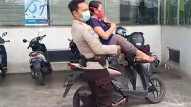 Aiptu Agus Riyanto, polisi yang bertugas di Polsek Kembangan Jakarta Barat saat membopong penyandang disabilitas demi mendapatkan vaksinasi. (Ist)