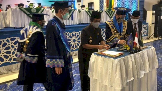 Wakil Bupati Kepulauan Selayar Saiful Arif saat menandatangani MoU bersama Rekror Unismuh Prof. Ambo Asse di hadapan wisudawan dan wisudawati, di Auditorium Kampus Unismuh Makassar, Kamis (24/02/2022). (Istimewa)