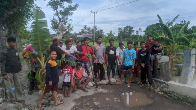Puluhan warga Desa Palajau, Kecamatan Arungkeke, Kabupaten Jeneponto, memblokade jalan dengan menanam pohon pisang di area jalan rusak, Minggu (27/2/2022). (Foto. Andi Nurul Gaffar/Republiknews.co.id)