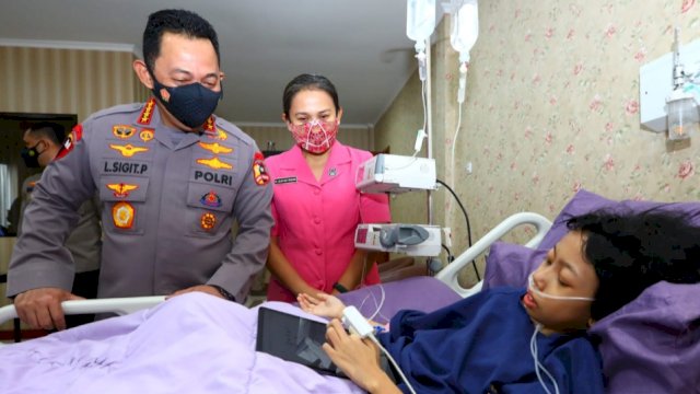 Kapolri Jenderal Listyo Sigit Prabowo bersama istri menjenguk Sinta, penderita tumor kaki di kamar perawatan RS Polri, Kramat Jati, Jakarta Timur, Minggu (20/2/2022). (Foto: Humas Polri)