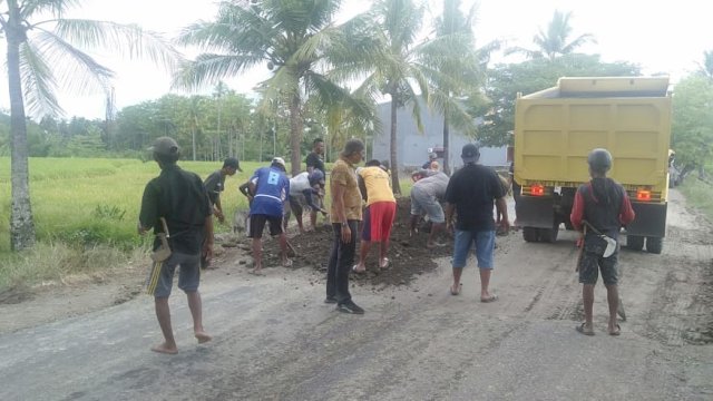Masyarakat Gotong Royong Menimbun jalan Provinsi di Desa Maccile, Kelurahan Lalabata Rilau yang berlubang. (Foto : Yusuf)