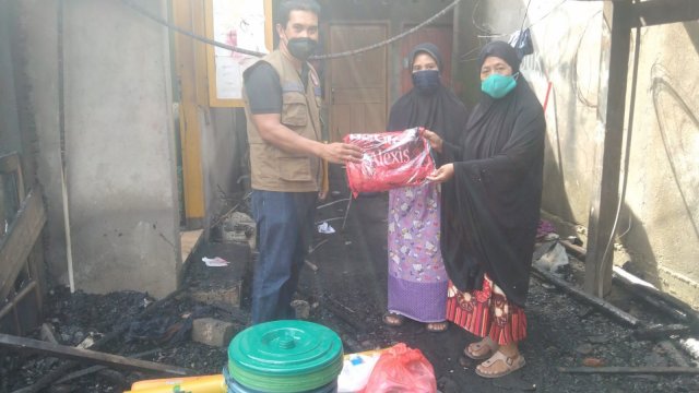 Anggota BPBD Sulsel menyerahkan bantuan secara simbolis kepada salah satu korban kebakadan di Jalan Daeng Tata 7, Kelurahan Parantambung, Kecamatan Tamalate, Kota Makassar. (Istimewa)