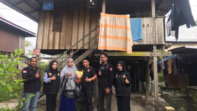 Garda Pemuda Nasdem Kabupaten Sidrap saat membagikan minyak goreng kepada warga di Desa Tonrong Rijang, Kecamatan Baranti, Jumat (18/03/2022). (Istimewa)