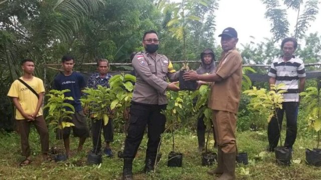 Penyerahan bibit kopi Robusta oleh Bhabinkamtibmas Polsek Muting, Aipda Jasman Tristanto kepada kelompok tani di Kampung Seed Agung Muting Merauke. (Ist)