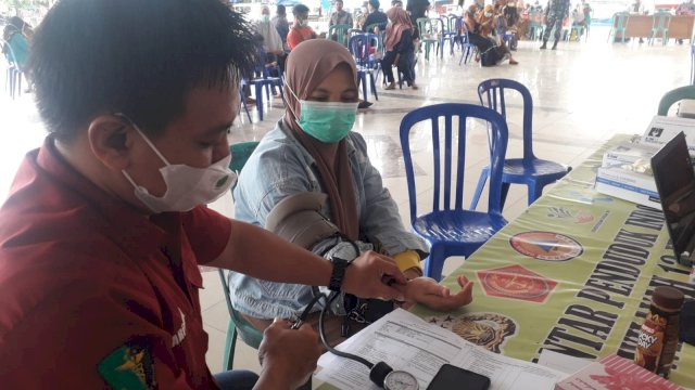 Seorang warga mengikuti vaksinasi massal yang digelar di Tribun Lapangan Passamaturukan, Kabupaten Jeneponto, Senin (28/03/2022). (Istimewa)