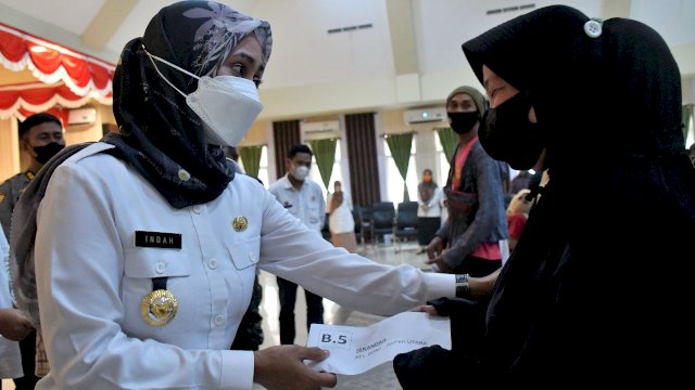 Bupati Luwu Utara, Indah Putri Indriani (kiri) saat menyerahkan kunci bantuan hunian tetap bagi penyintas banjir bandang, Rabu (2/3/2022). (Foto: Humas Pemkab Lutra)