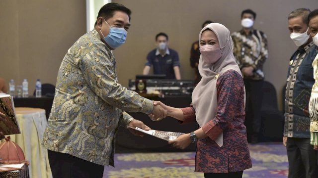 Bupati Luwu Utara, Indah Putri Indriani menerima komitmen bersama terkait kesanggupan untuk melakukan perbaikan dan pembenahan dalam implementasi reformasi birokrasi di lingkungan Pemerintah Daerah dari Sekretaris Provinsi Sulsel, Abdul Hayat Gani di Claro Hotel Makassar, Kamis (31/03/2022). (Istimewa)