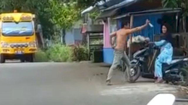 Tangkapan Layar Video Seorang pria di Kabupaten Takalar, Sulawesi Selatan menghadang sejumlah Pengendara Motor menggunakan sebilah parang, pengendara nyaris ditebas. (Istimewa)