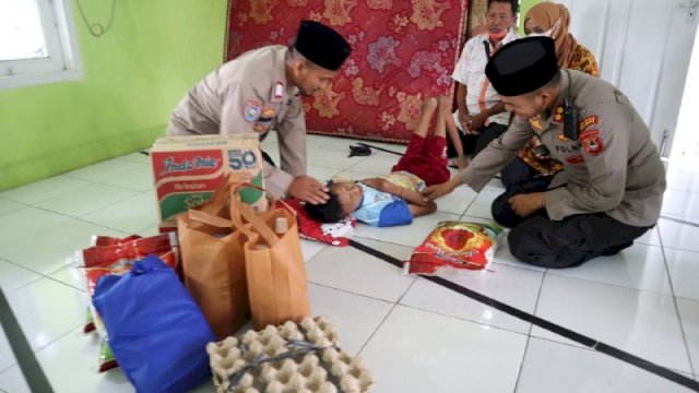Kapolres Palopo AKBP Muhammad Yusuf Usman, membantu warga yang Lumpuh Layu di Kelurahan Ponjalae, Kecamatan Wara Timur, Jumat (15/04/2022). (Dok. Polres Palopo)