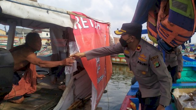 Kapolsek Kawasan Kali Baru Kompol Kasranto Menyisir Para Nelayan Membagi Bantuan Daging, Rabu (20/4/2022). (Istimewa)